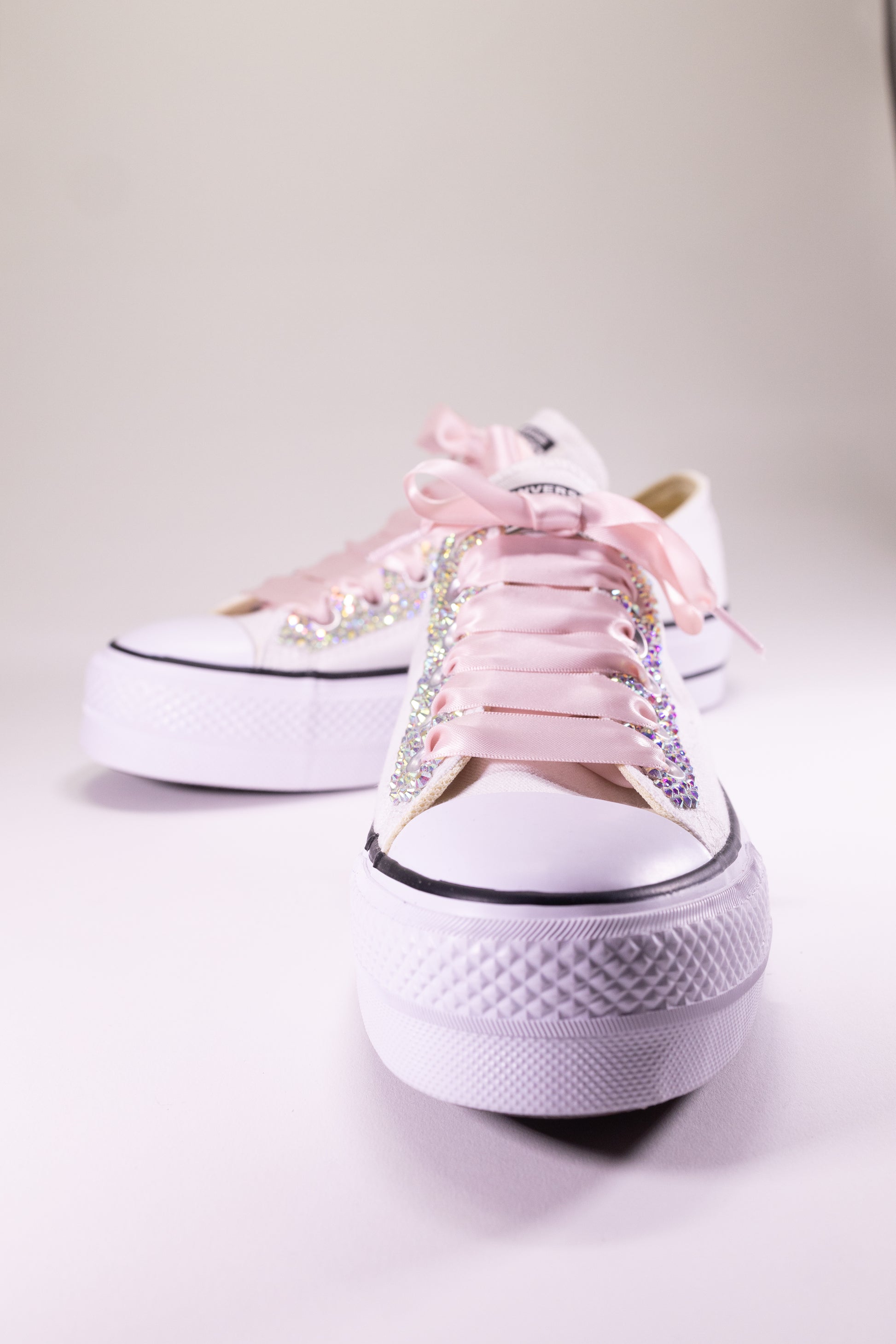 White sneakers with pink laces and rhinestone embellishments