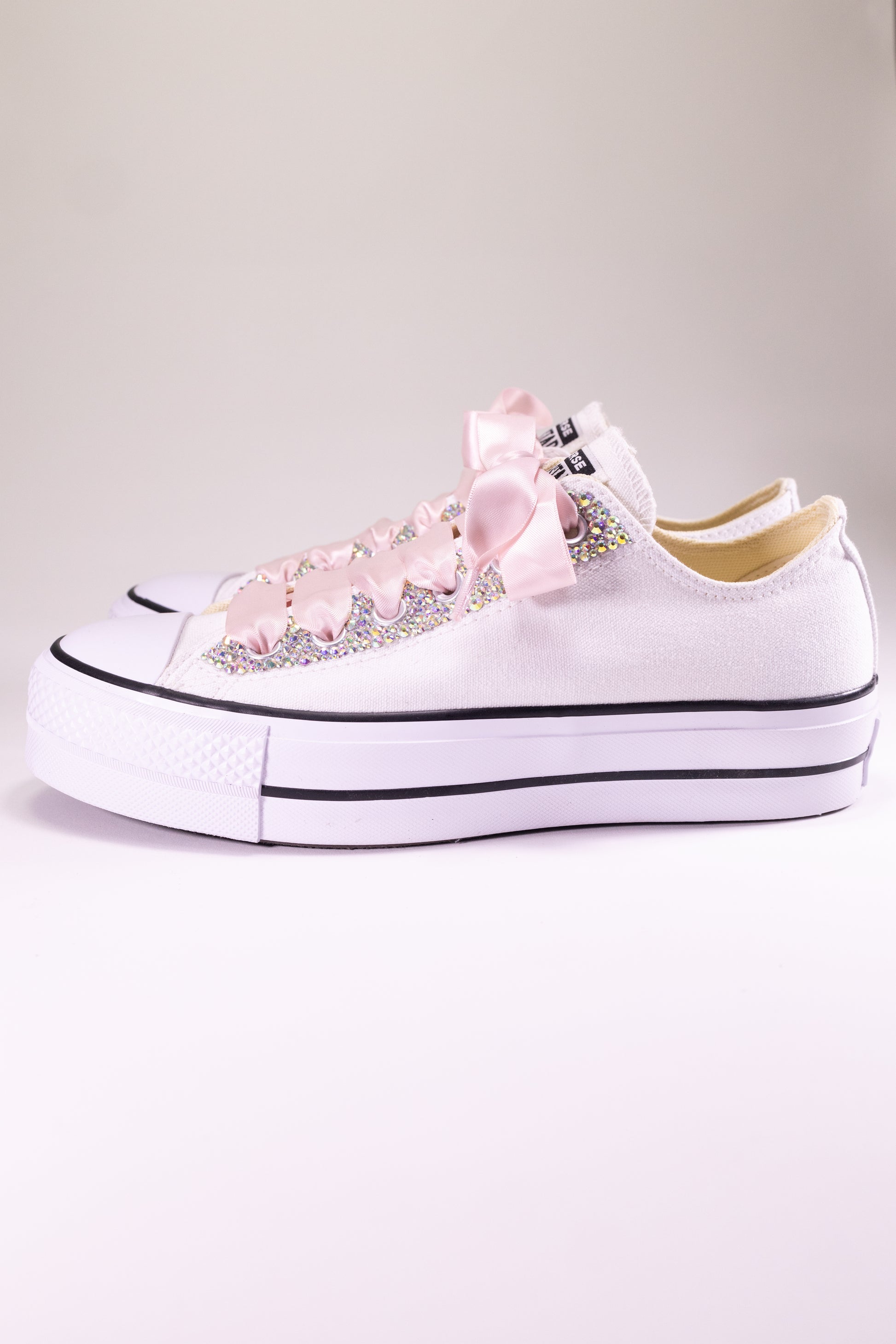 White sneakers with rhinestone embellishments and pink laces