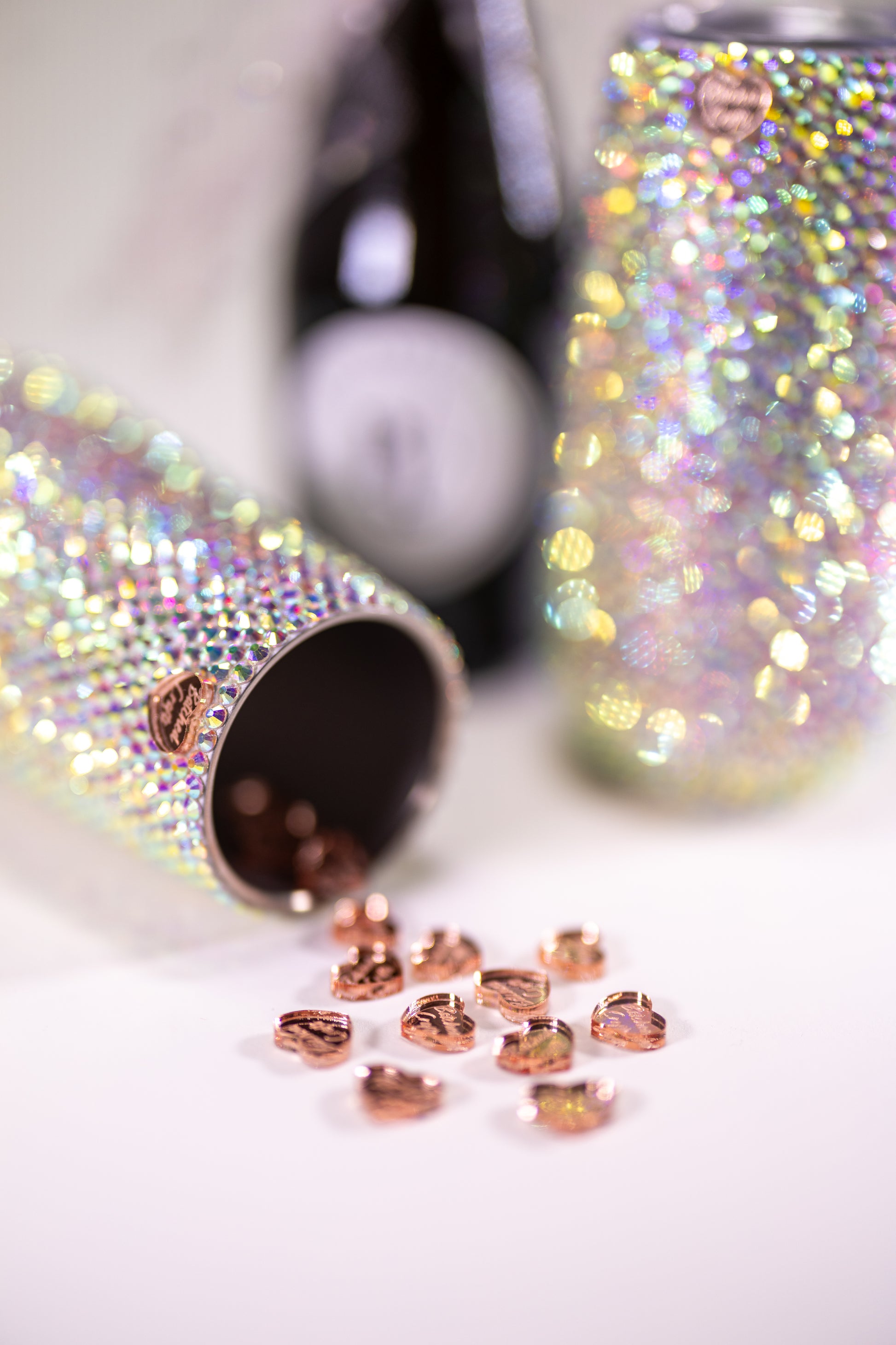 Close up shot of sparkling tumblers with mini wine bottle in the background
