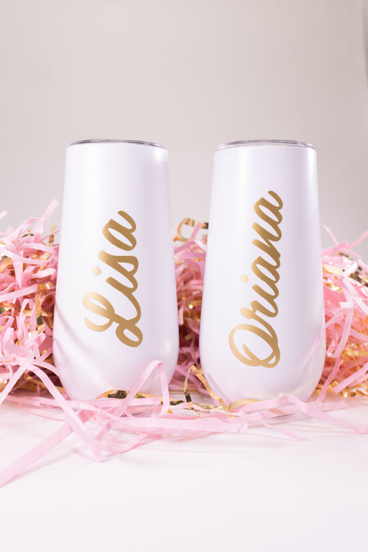 Two white stemless tumblers with gold names.